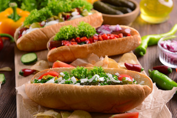 Hot dogs and vegetables on wooden cutting board