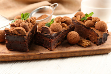 A piece of chocolate cake with walnut and mint on the table, close-up