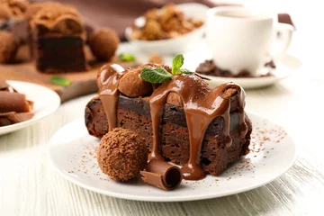 Foto op Plexiglas Dessert Een stuk chocoladetaart met munt op tafel, close-up