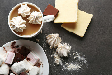 Cup of coffee and sweets on black wooden background