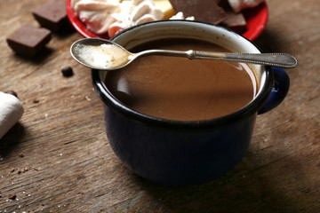 Cup of coffee with sweets on wooden background
