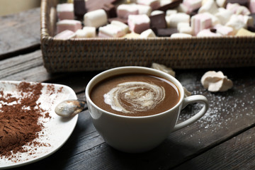 Cup of coffee with sweets on wooden background