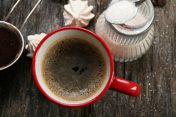 Cup of coffee with sweets on wooden background