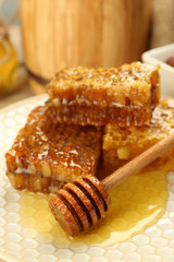 Honeycombs on plate on wooden background