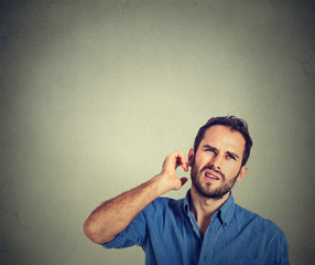 man scratching head, thinking deeply about something, looking up