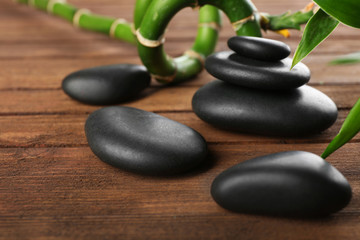 Obraz na płótnie Canvas Spa stones and bamboo branch on wooden background
