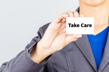 Take Care message on the card held by a man hand