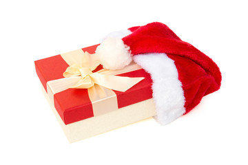 red gift box with bow covered by a santa claus hat