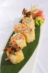 sushi covered in fish eggs served on a leaf