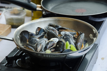 mussels with white wine and cream sauce being cooked in a pan