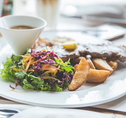 Beef grill steak with salad and fried wedges potato