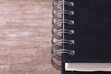Black Notebook on Wooden Background.