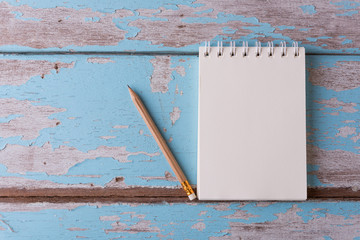 Top view work space notebook and brown pencil on old blue wood t