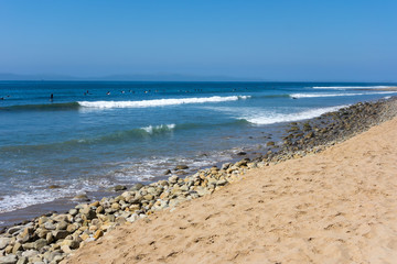 Fototapeta na wymiar California surfers catching waves between Ventura City Beach and distant Channels Islands