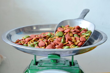 dog food in iron scoop on weighing scale