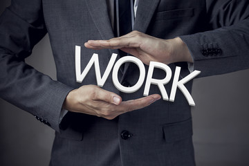 Businessman in suit with two hands in position to protect the wo