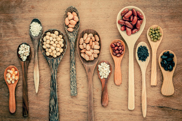 Fototapeta na wymiar Assortment of beans and lentils in wooden spoon on teak wood bac