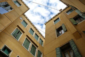 Old buildings with yellow walls and green wooden shutters