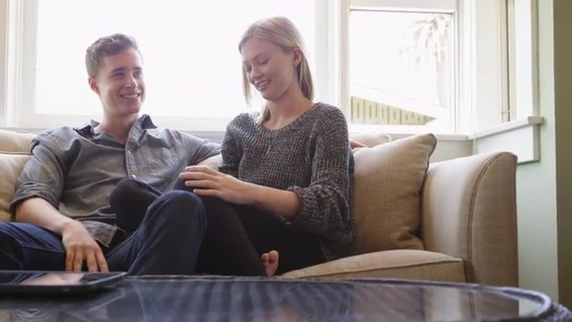 Couple talking on couch in their new apartment
