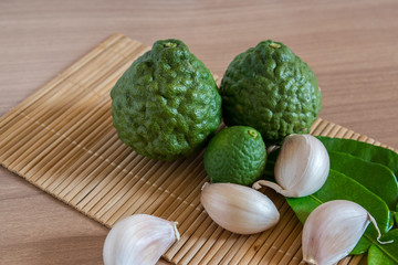 bergamot and garlic on makisu mat on wood texture