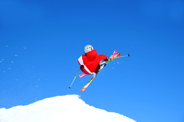 Naklejka na ściany i meble skier in red taking off on a jump