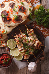 Chicken tikka on skewers, naan flat bread closeup. vertical top view   © FomaA