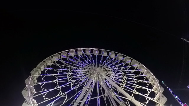 Ferris Wheel slow motion in amusement park at night.