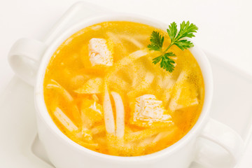 Chicken noodle soup in white mug