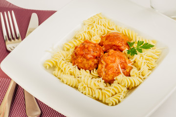 Fusilli pasta with meatball at white plate