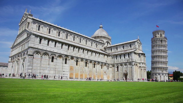 General view at leaning tower of The Piazza dei Miracoli (Piazza del Duomo) with many tourists under clear sunny sky in Tuscany. 