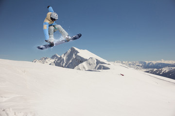 Flying snowboarder on mountains