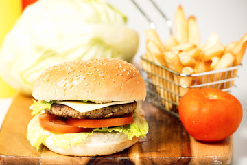 Hamburger with cheese, potato chips and ingredients on a white background