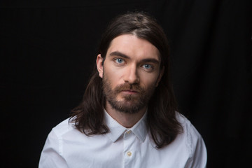 Man with beard and long hair looking at camer