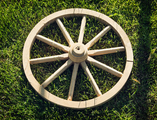 Old wooden wheel on the grass