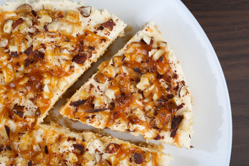 Homemade coconut cheesecake with caramel and assorted nuts
