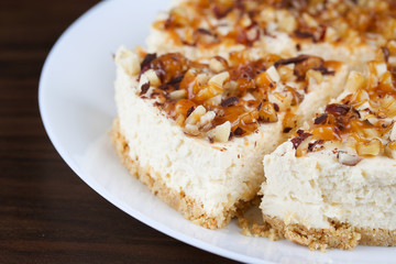 Homemade coconut cheesecake with caramel and assorted nuts