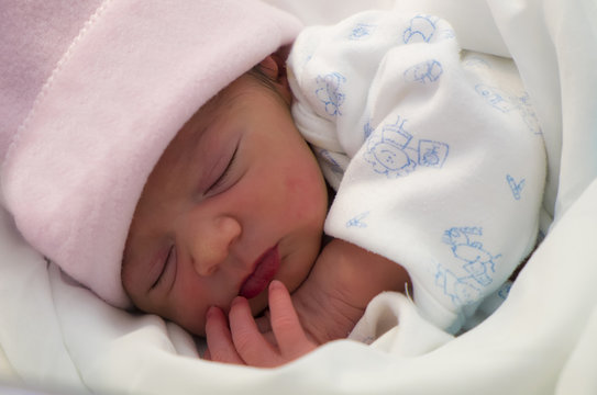 Bebé recién nacido durmiendo feliz tras la toma de leche mediante la lactancia