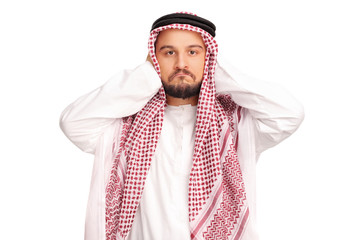 Reluctant male Arab covering his ears