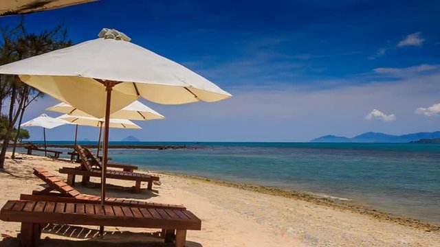beach umbrellas chairs on gold sand against azure sea