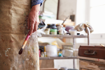 Close Up Of Female Artist Holding Brush In Studio