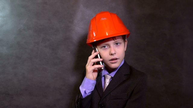 teen portrait boy builder in helmet smiling talking on phone smartphone