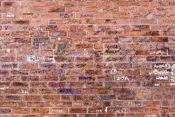 Random names written on brick wall.