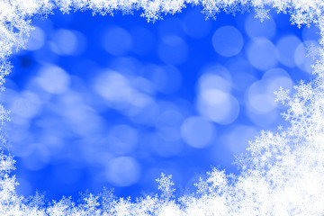 blue bokeh background and white snowflakes frame with copyspace.