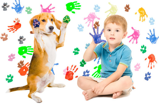 Cute boy with Beagle sitting  on the background of handprints