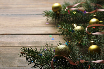 Obraz na płótnie Canvas fir-tree branch and Christmas toys with confetti on wooden background