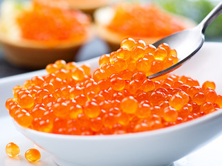 Caviar. Red caviar in spoon on a white background. Gourmet food closeup
