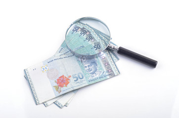 Magnifier glass and money on white background. Financial concept