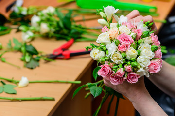 closeup florist making a bouquet of flowers. Shallow depth of fi