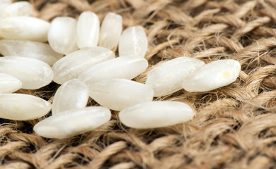 Grains of white rice on the sackcloth - macro.