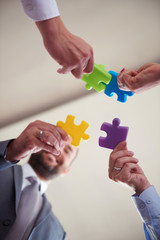 business people group assembling jigsaw puzzle